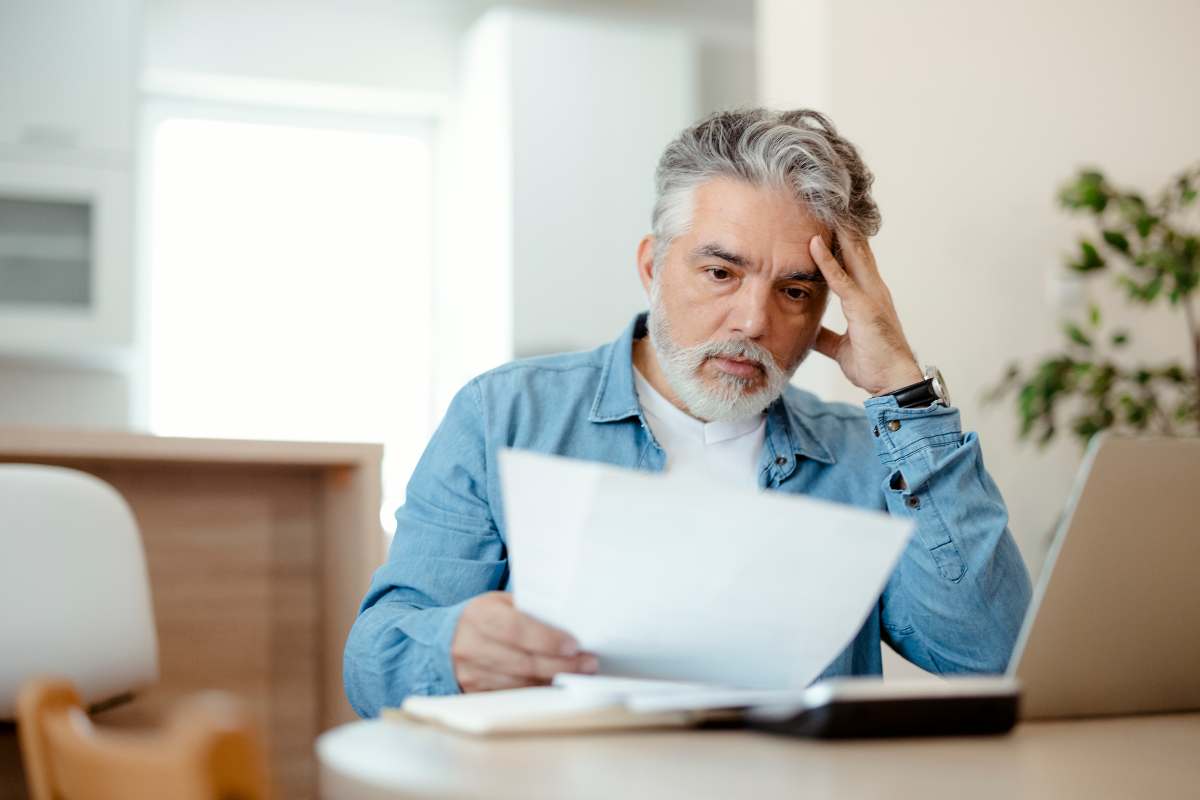 uomo preoccupato legge dei fogli